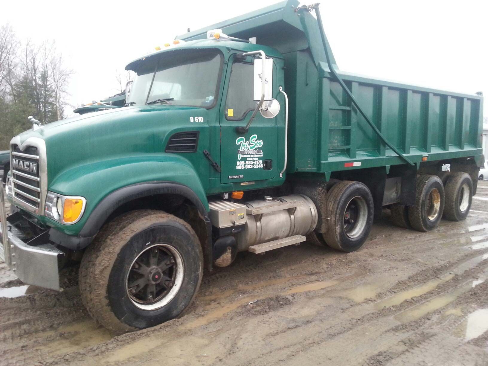 Green dump truck on muddy road