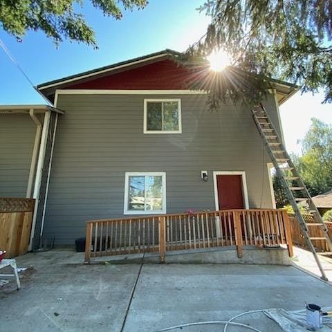 Gray building with a wooden ramp and ladder.