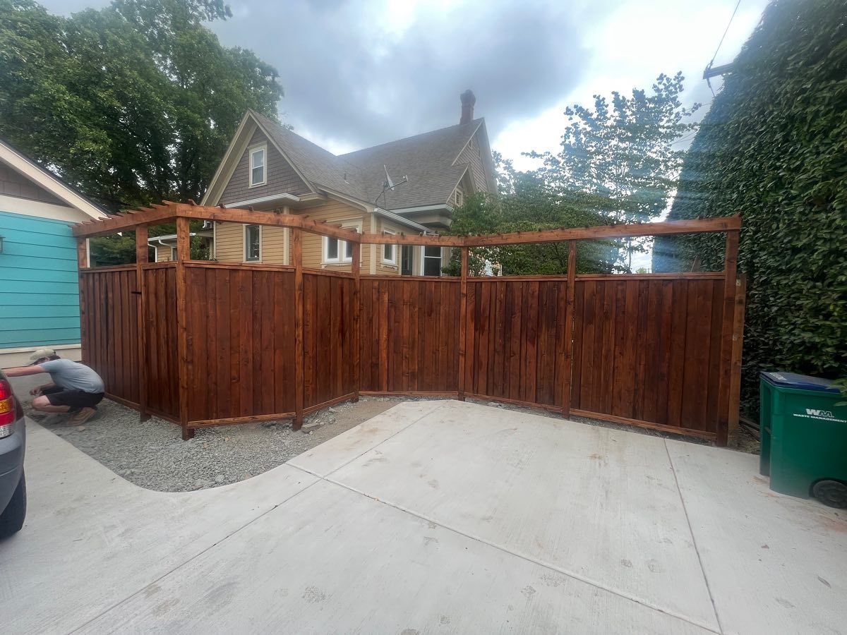 Brown wooden fence in a driveway.