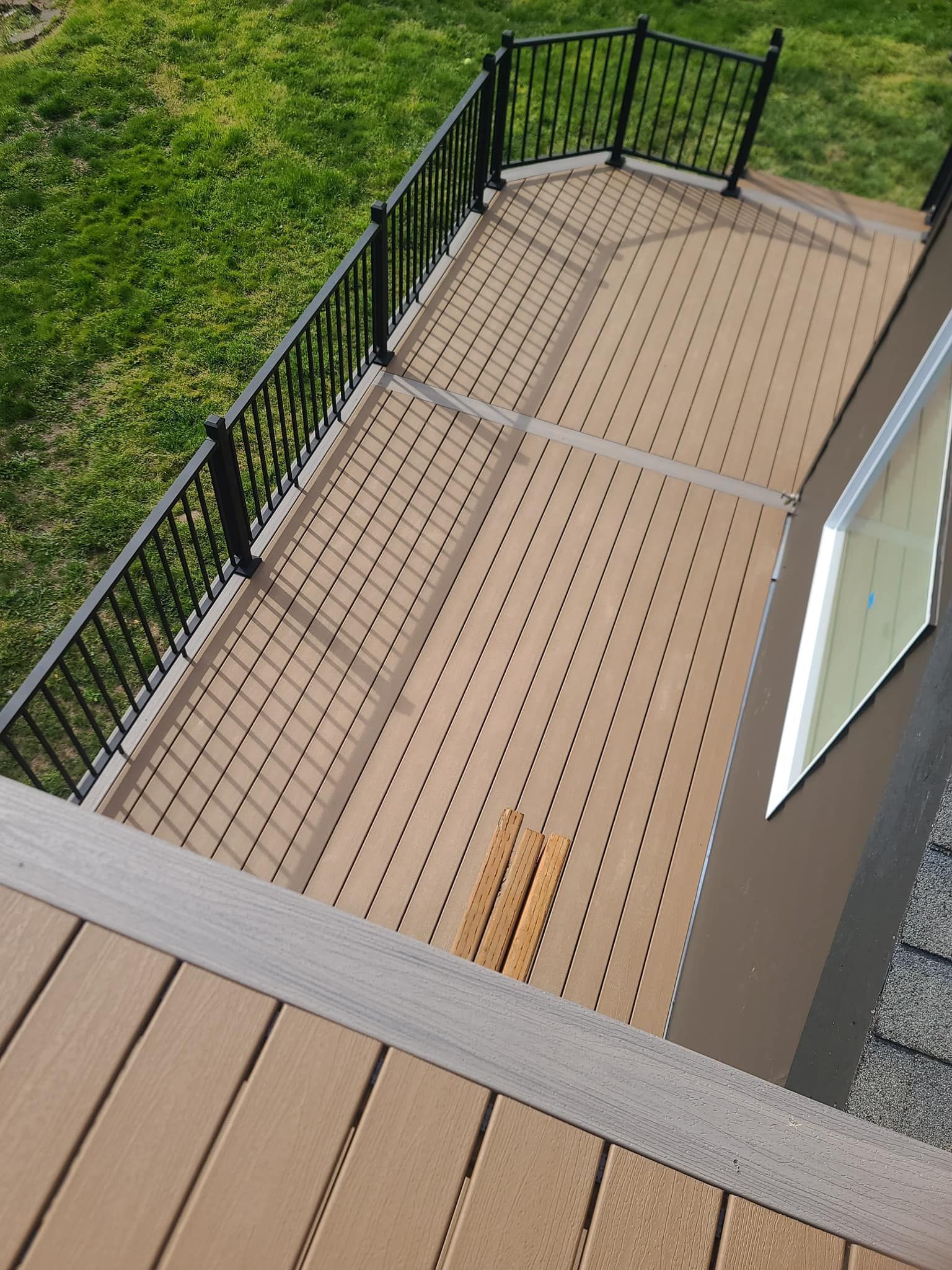 Brown deck with black railing and perforated surface.