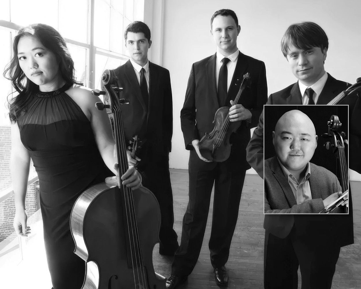 A group of people standing next to each other holding violins