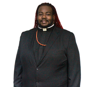 Person in black suit with clerical collar and red dreadlocks.