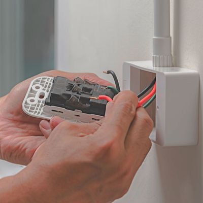 ProTech Athens | a person is installing a light switch on a wall