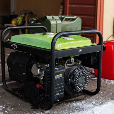 ProTech Athens | a green generator is sitting on the ground next to a red gas can.