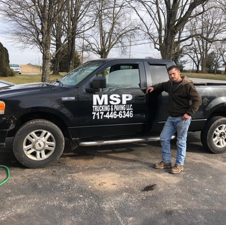 A man standing next to a truck that says msp on the side
