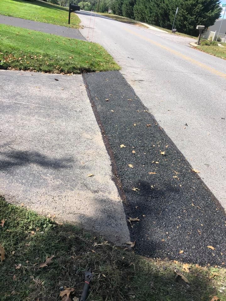 There is a mailbox on the side of the road next to a sidewalk.