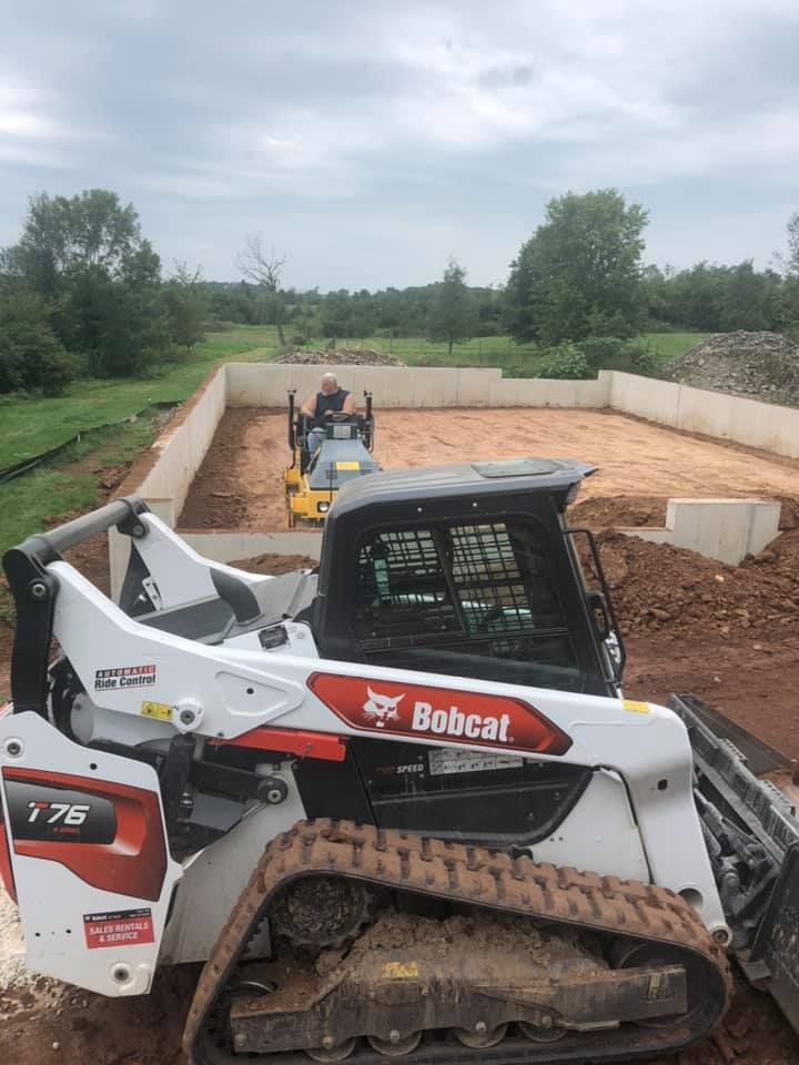 A bobcat bulldozer is sitting on top of a dirt field.