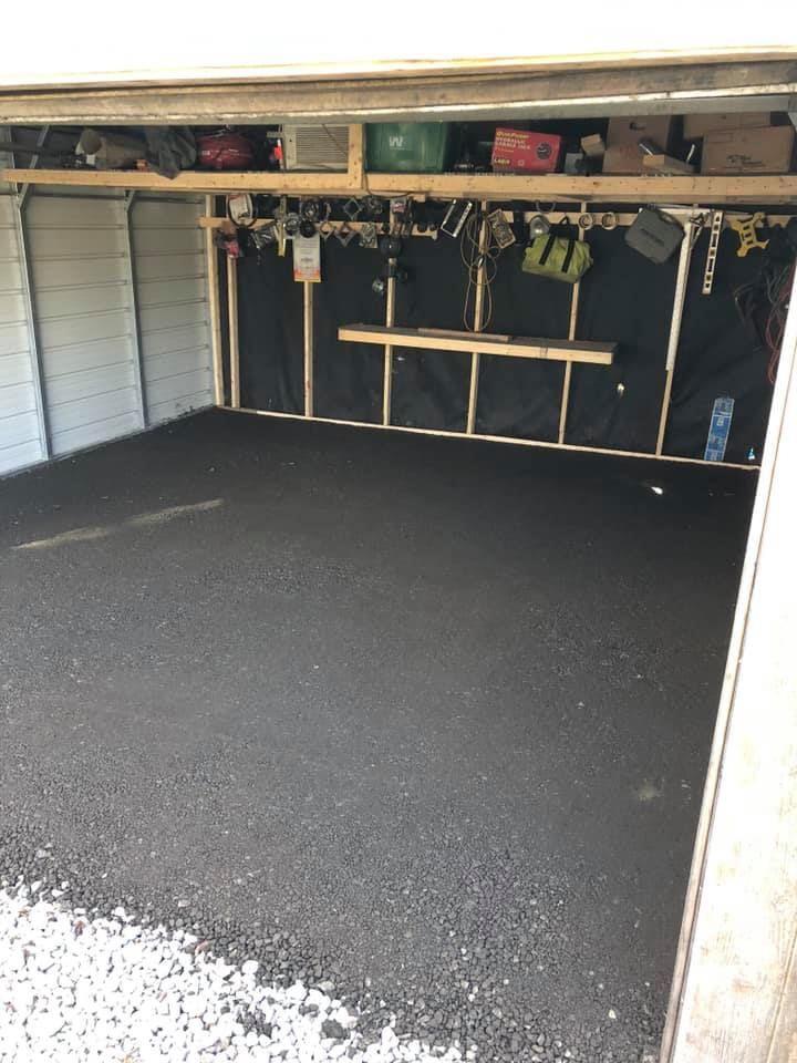 A garage with a black floor and a white wall
