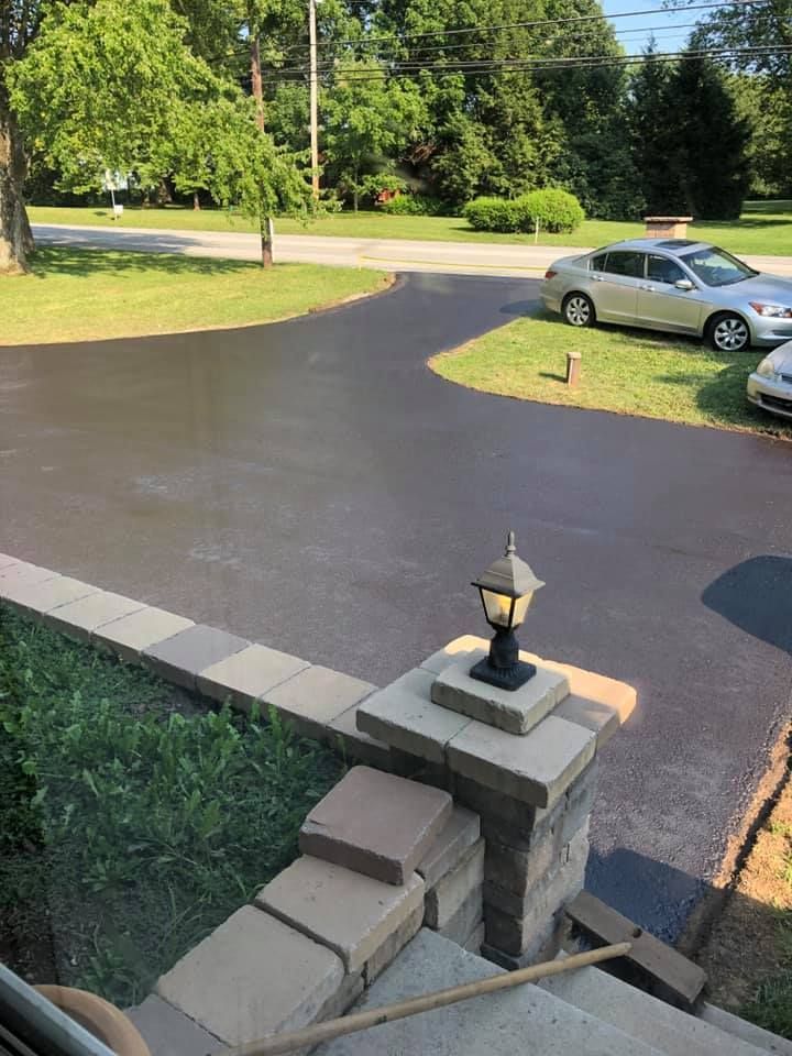 A car is parked in a driveway next to a lamp post.