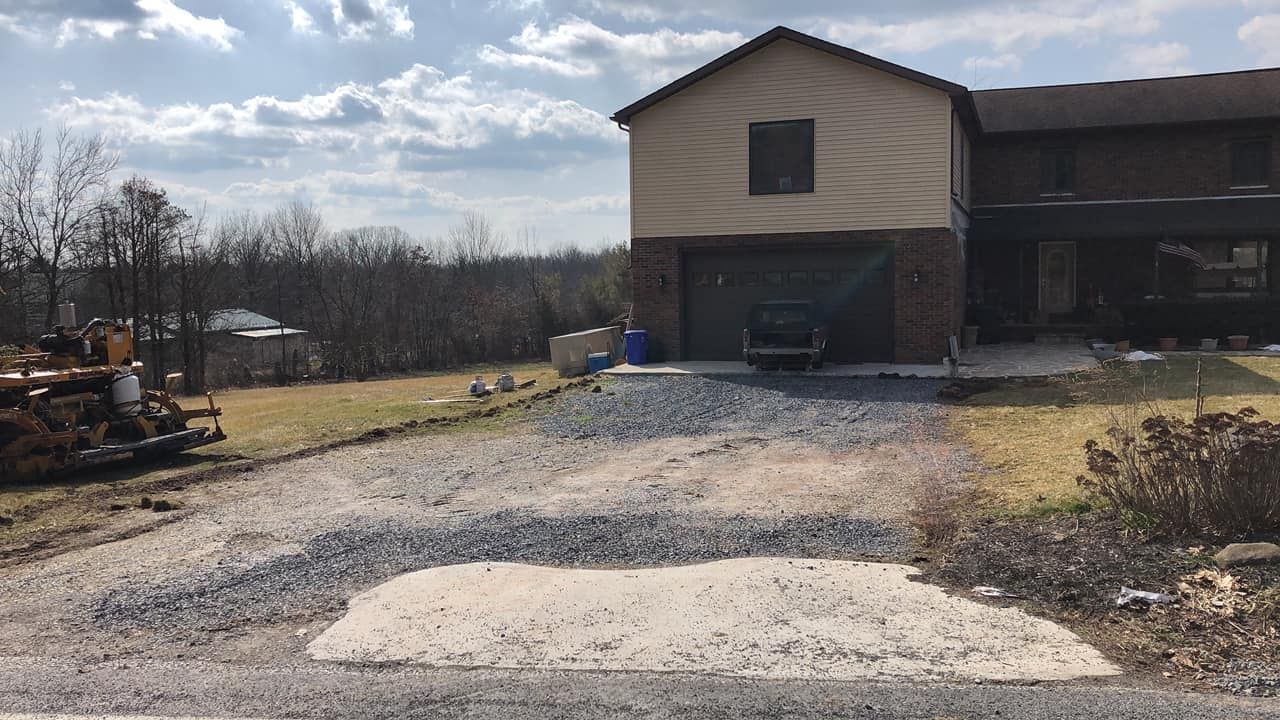A large house with a gravel driveway in front of it.