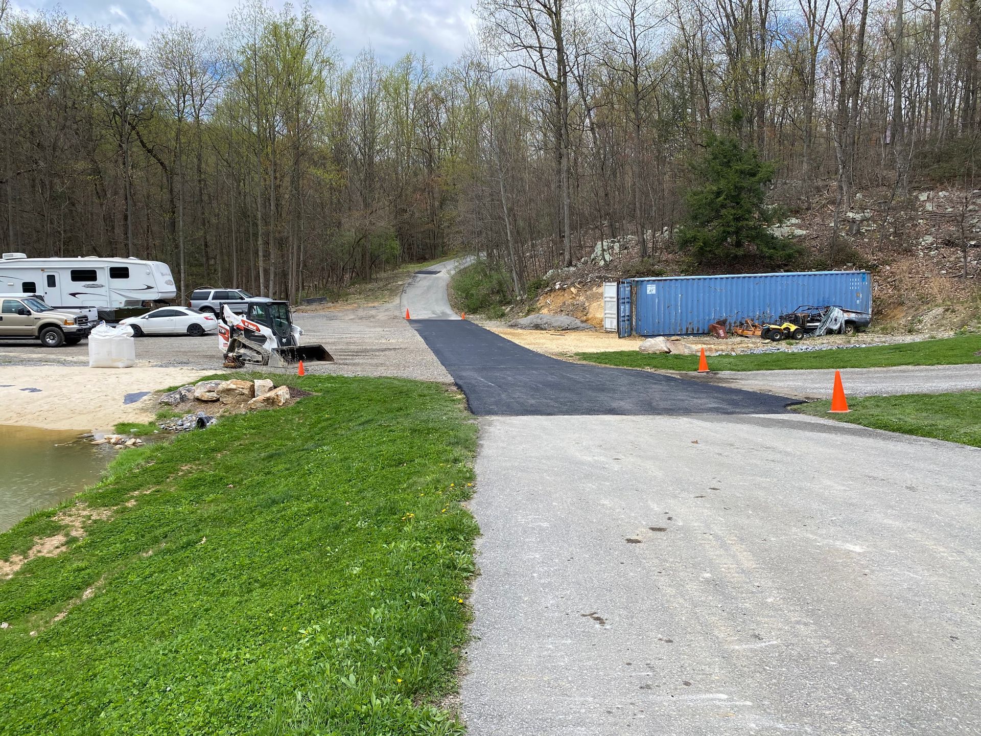 A road that is going through a park with a lot of grass and trees.