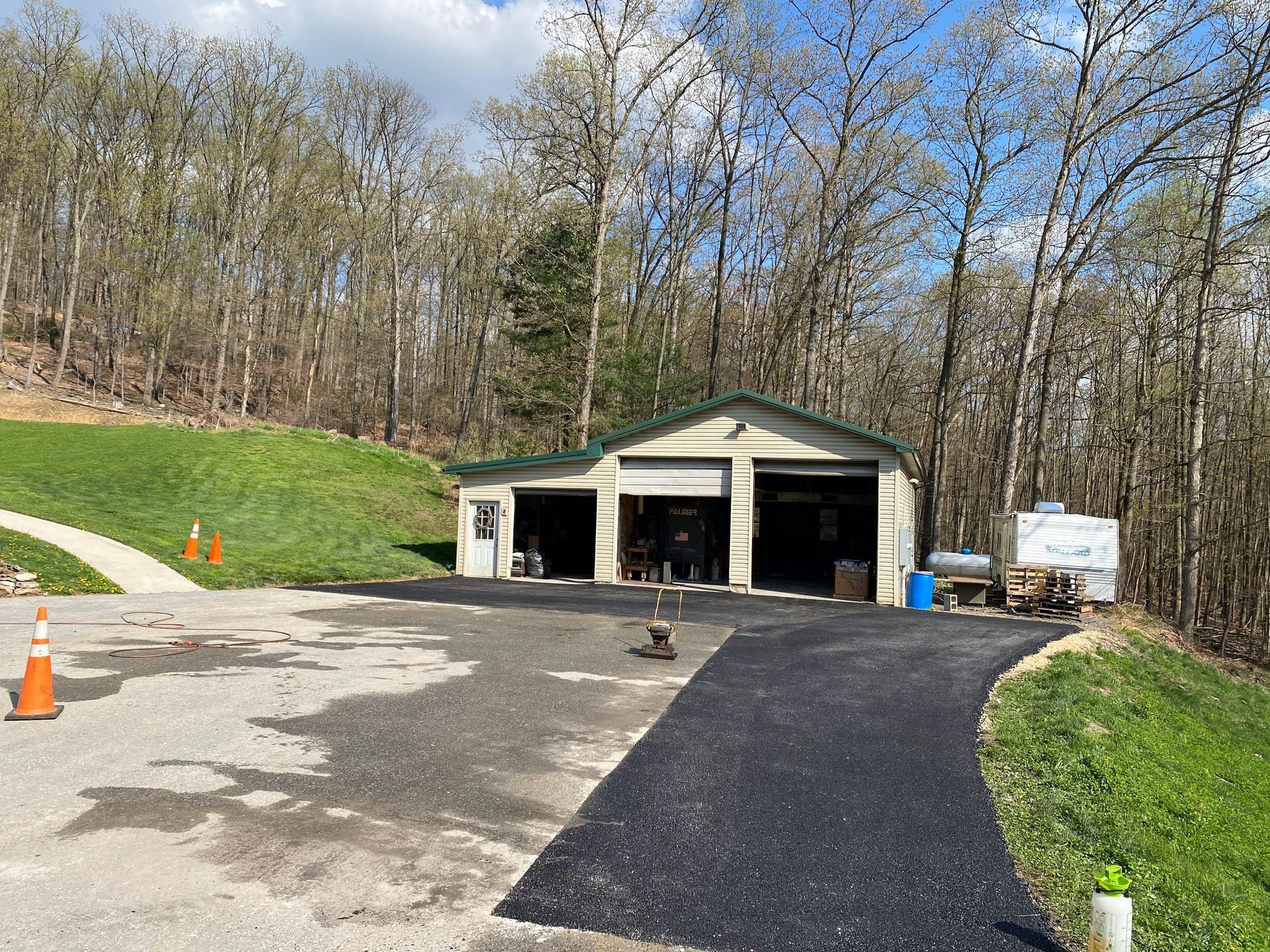 A garage is sitting on top of a hill next to a road.