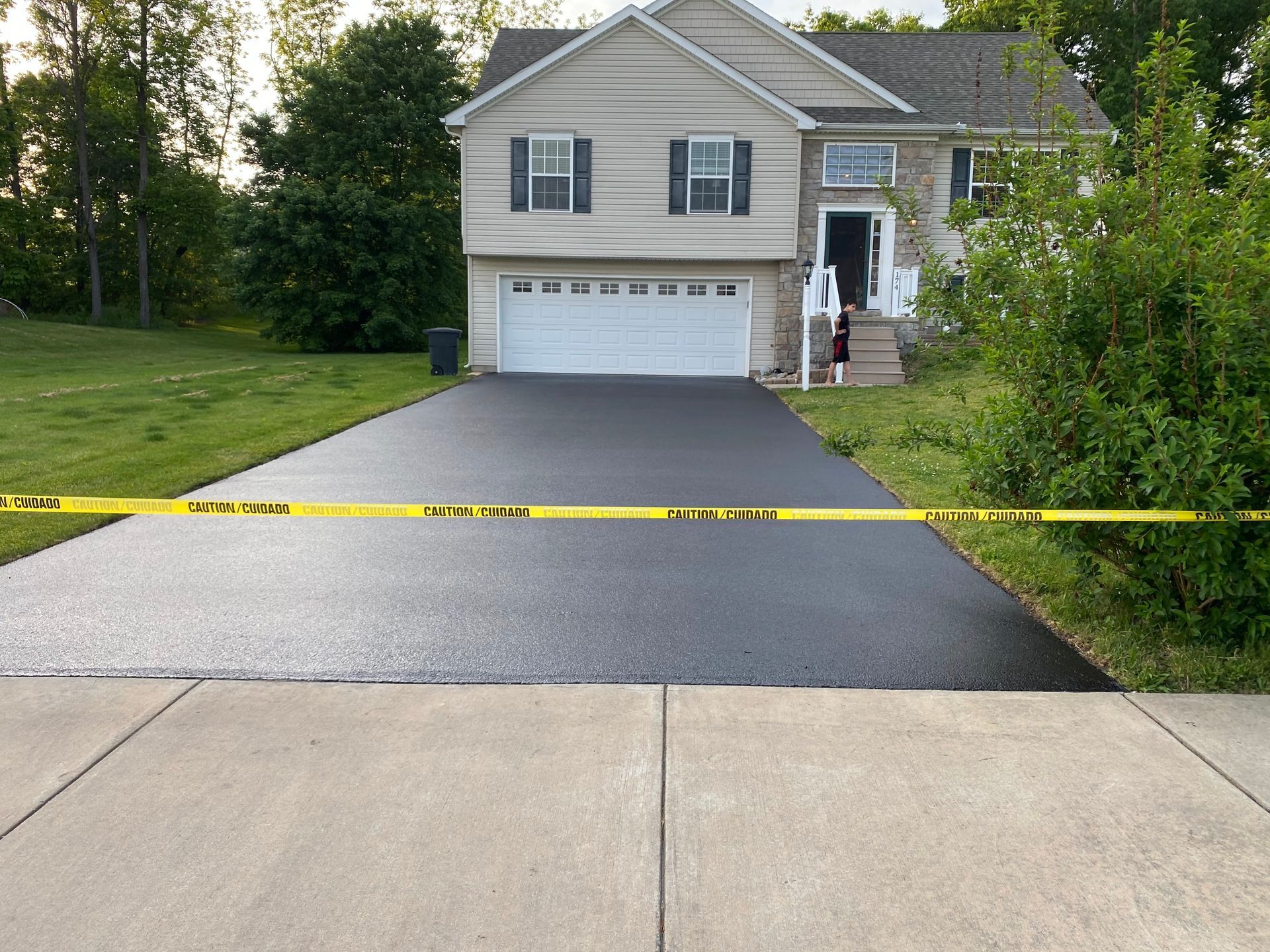 A house with a black driveway and a yellow caution tape