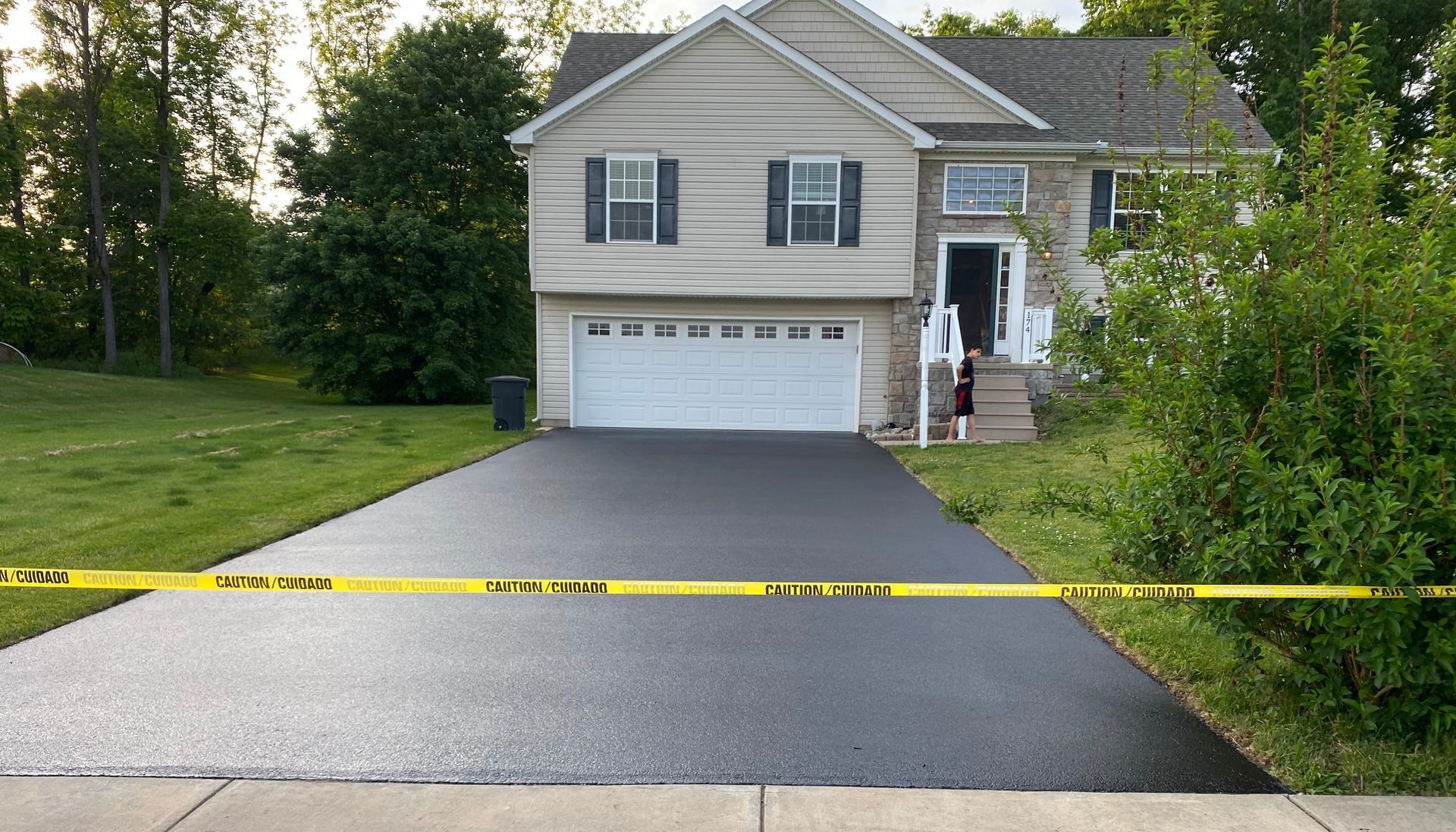 A house with a driveway that is covered in yellow tape