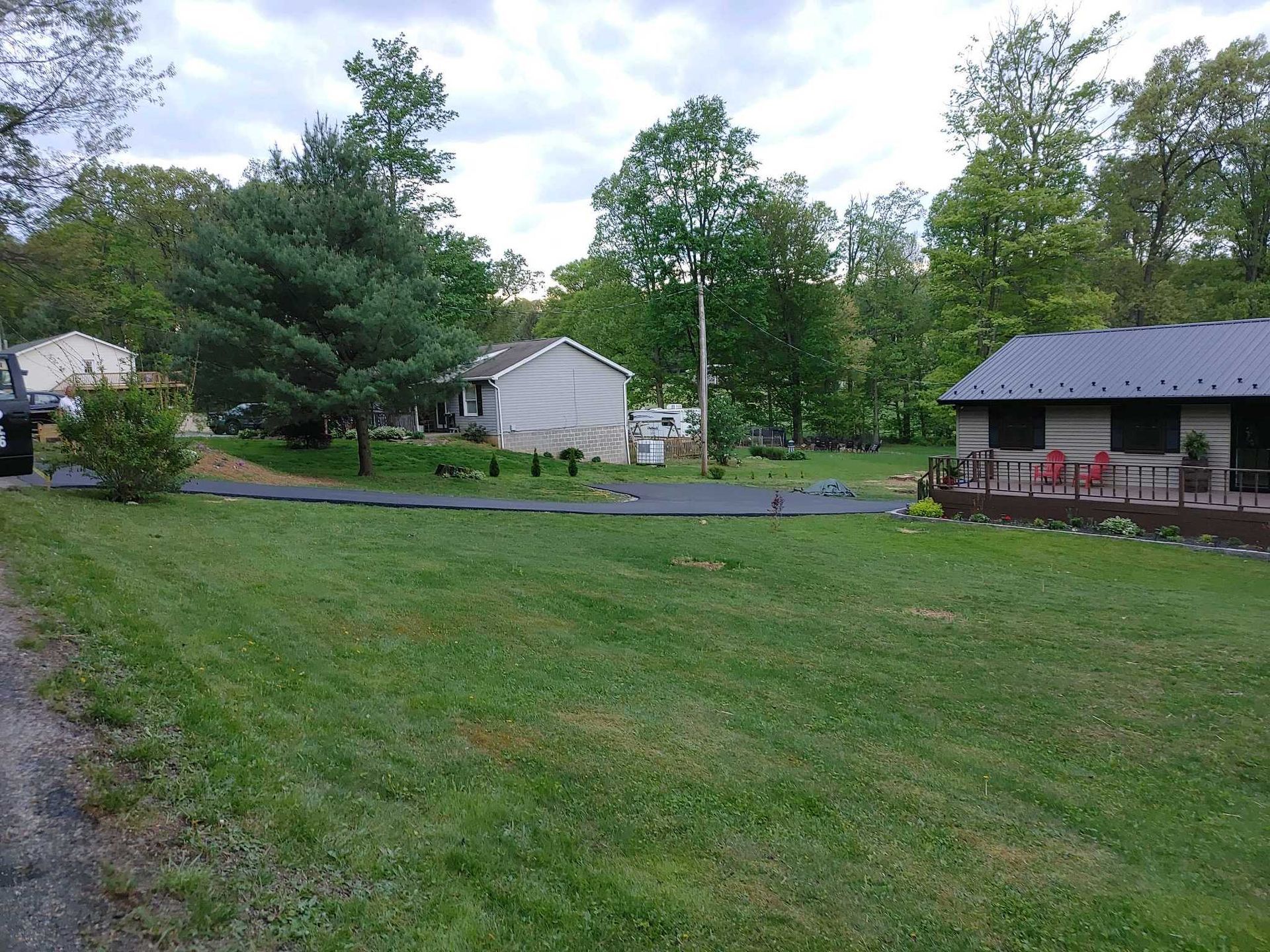 A house is sitting in the middle of a lush green field surrounded by trees.