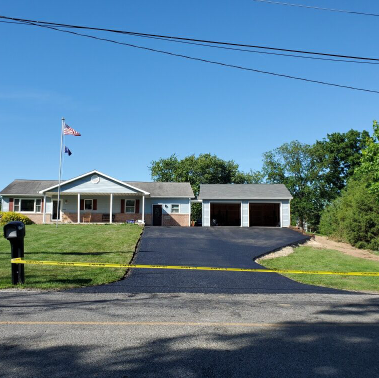 A house with a driveway and a mailbox in front of it