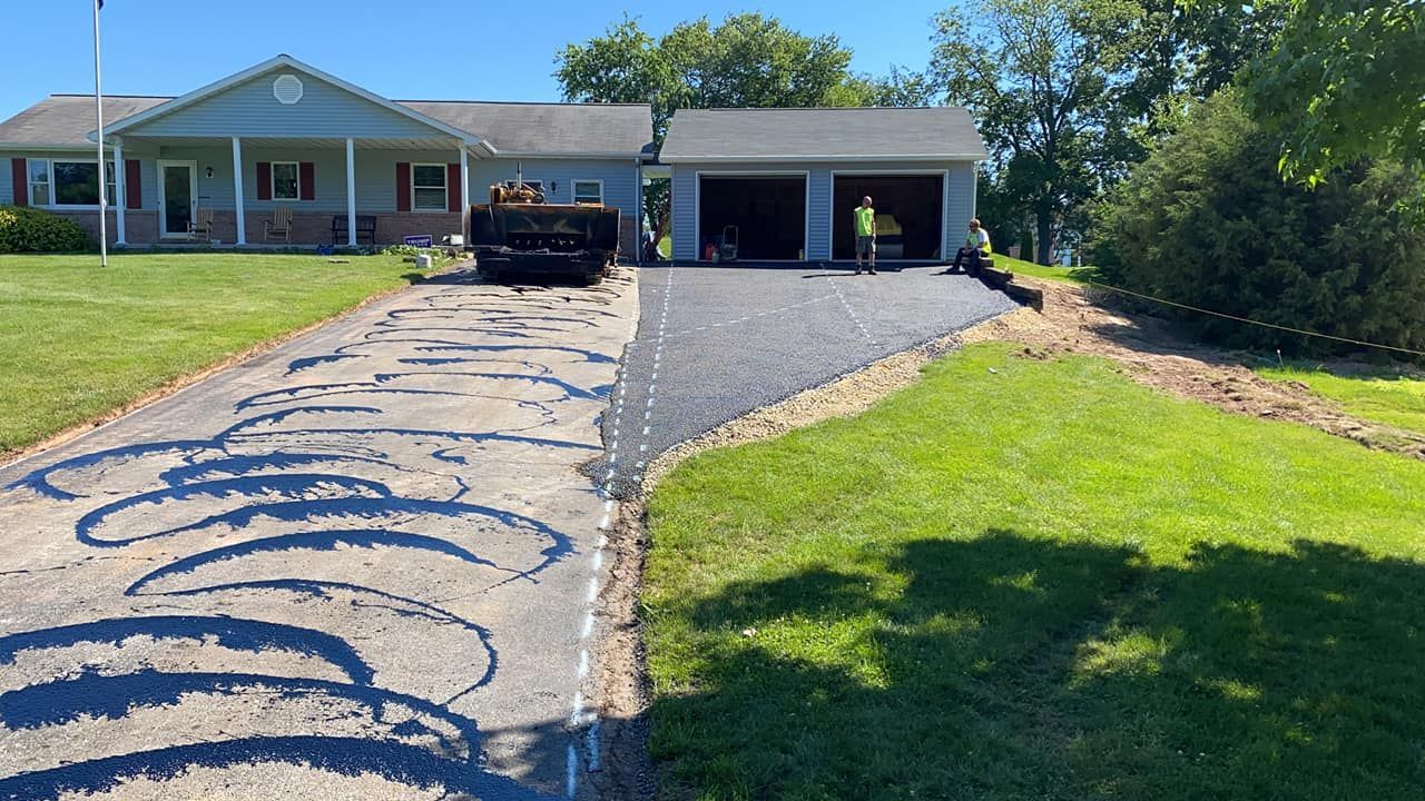A driveway is being paved in front of a house.