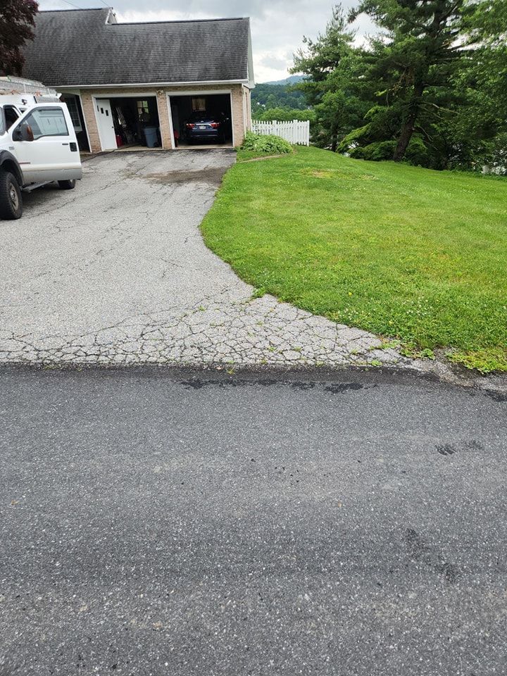 A white truck is parked in a driveway in front of a house.