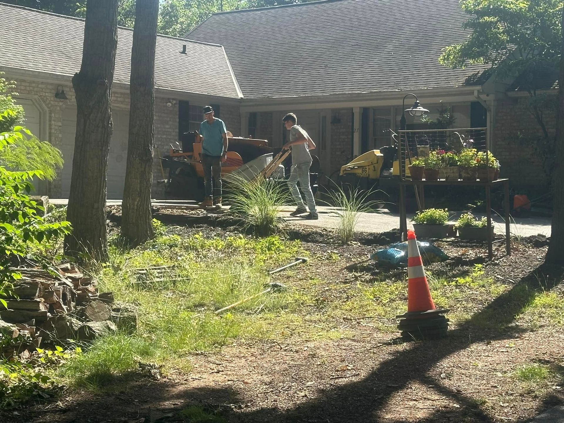 A man is pushing a wheelbarrow in front of a house
