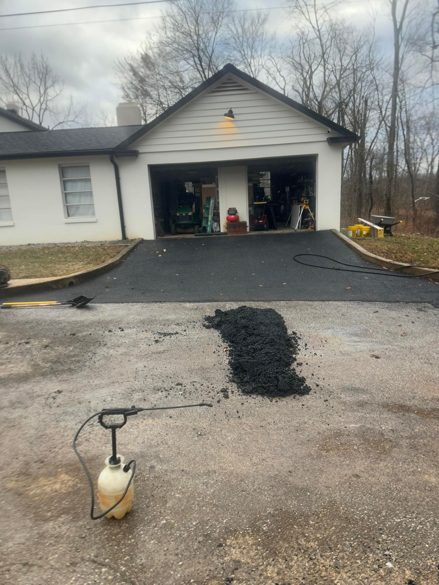 A spray bottle is sitting on the ground in front of a house.