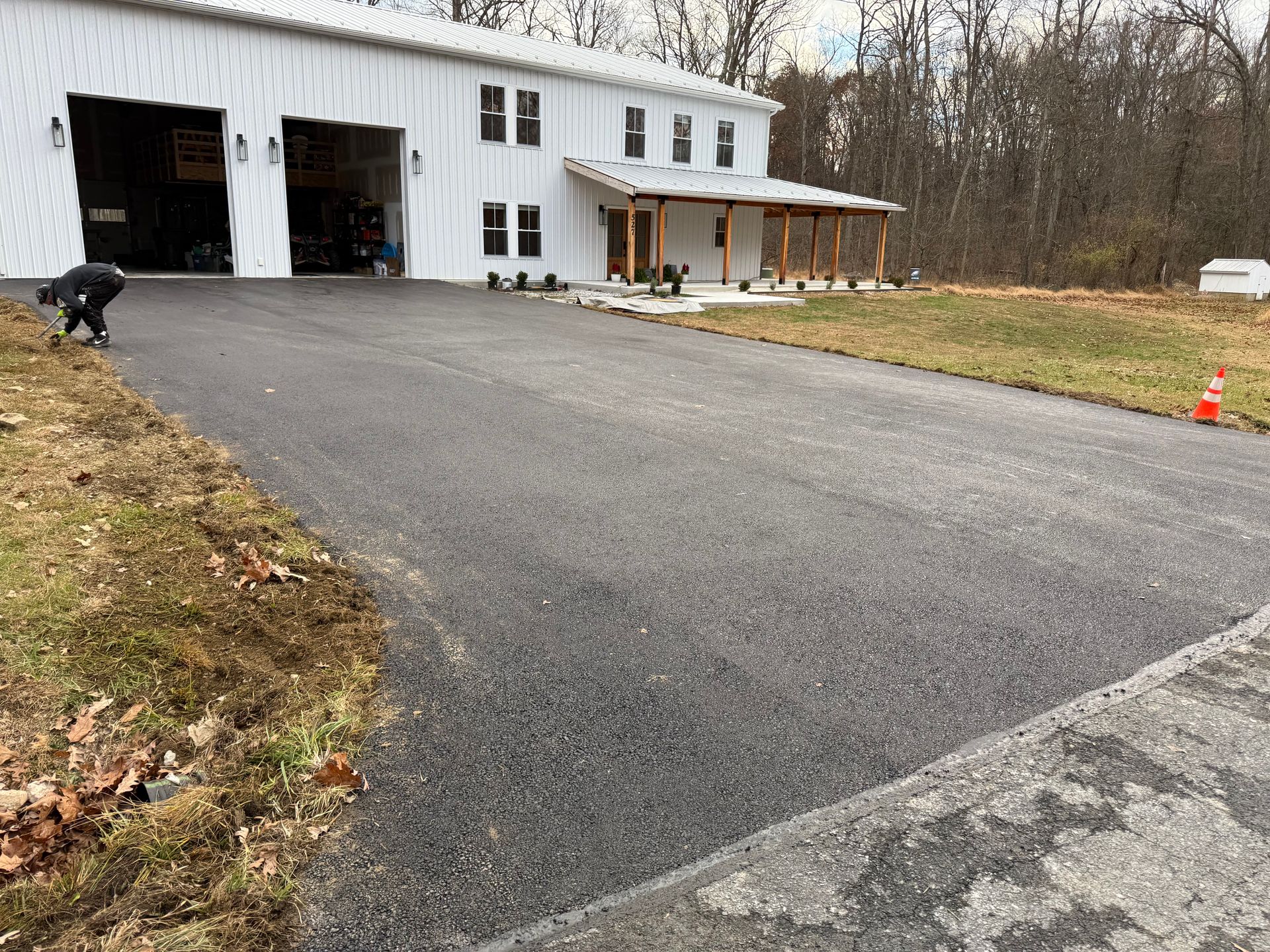 A close up of a pile of black gravel on the side of a road.