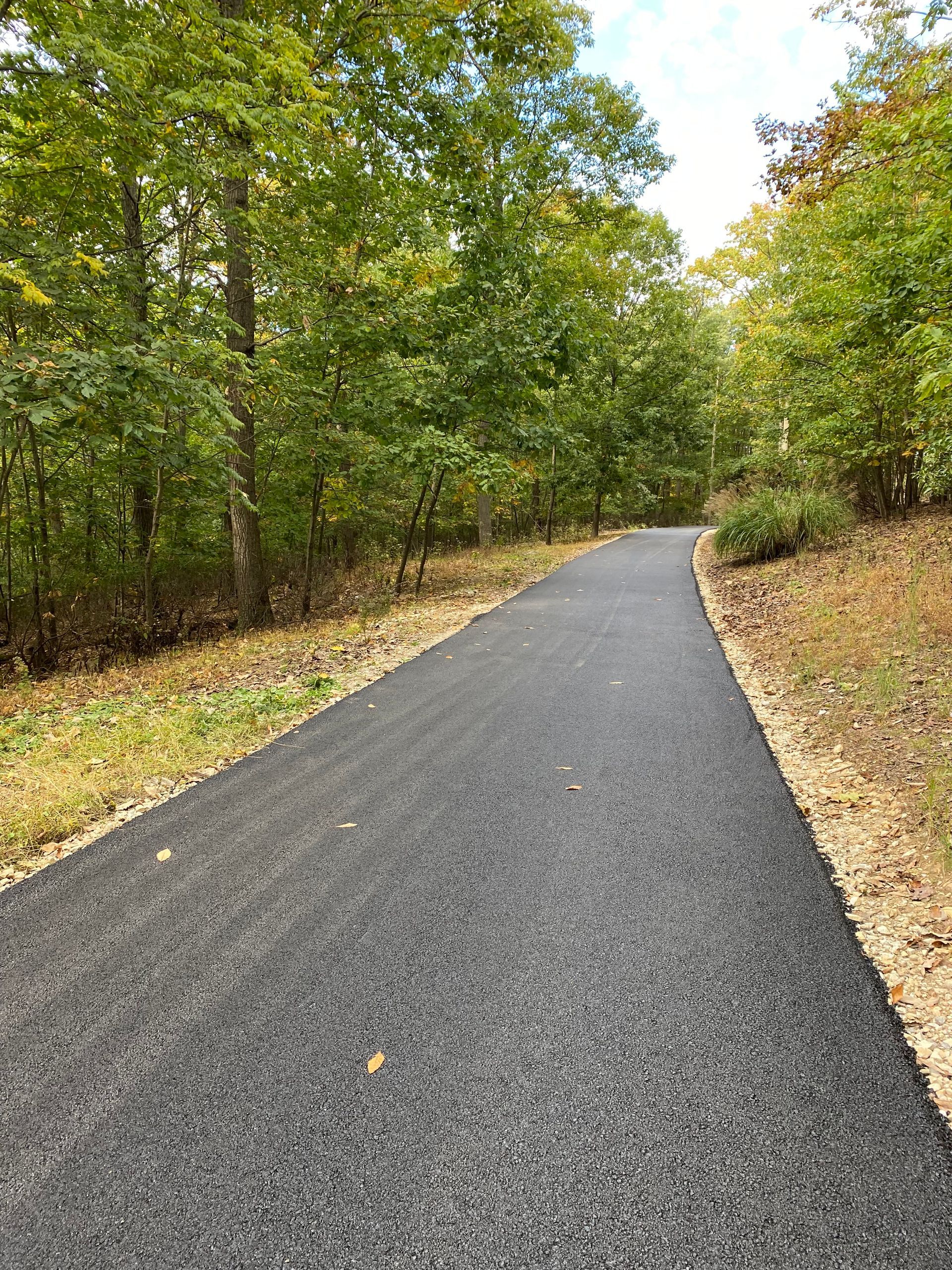 Orange traffic cones on the side of a road at sunset