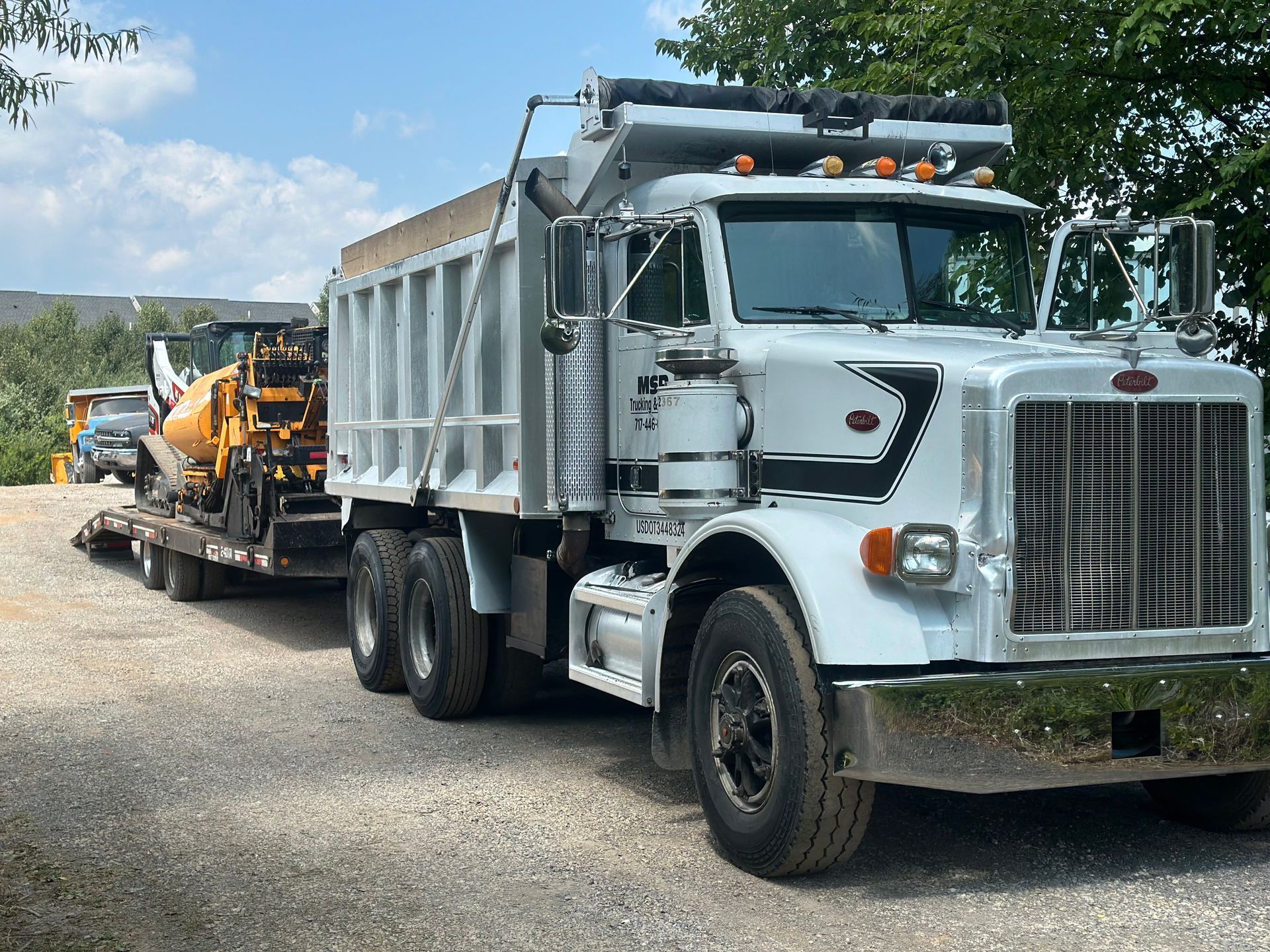 A dump truck is driving down a street next to a stop sign.