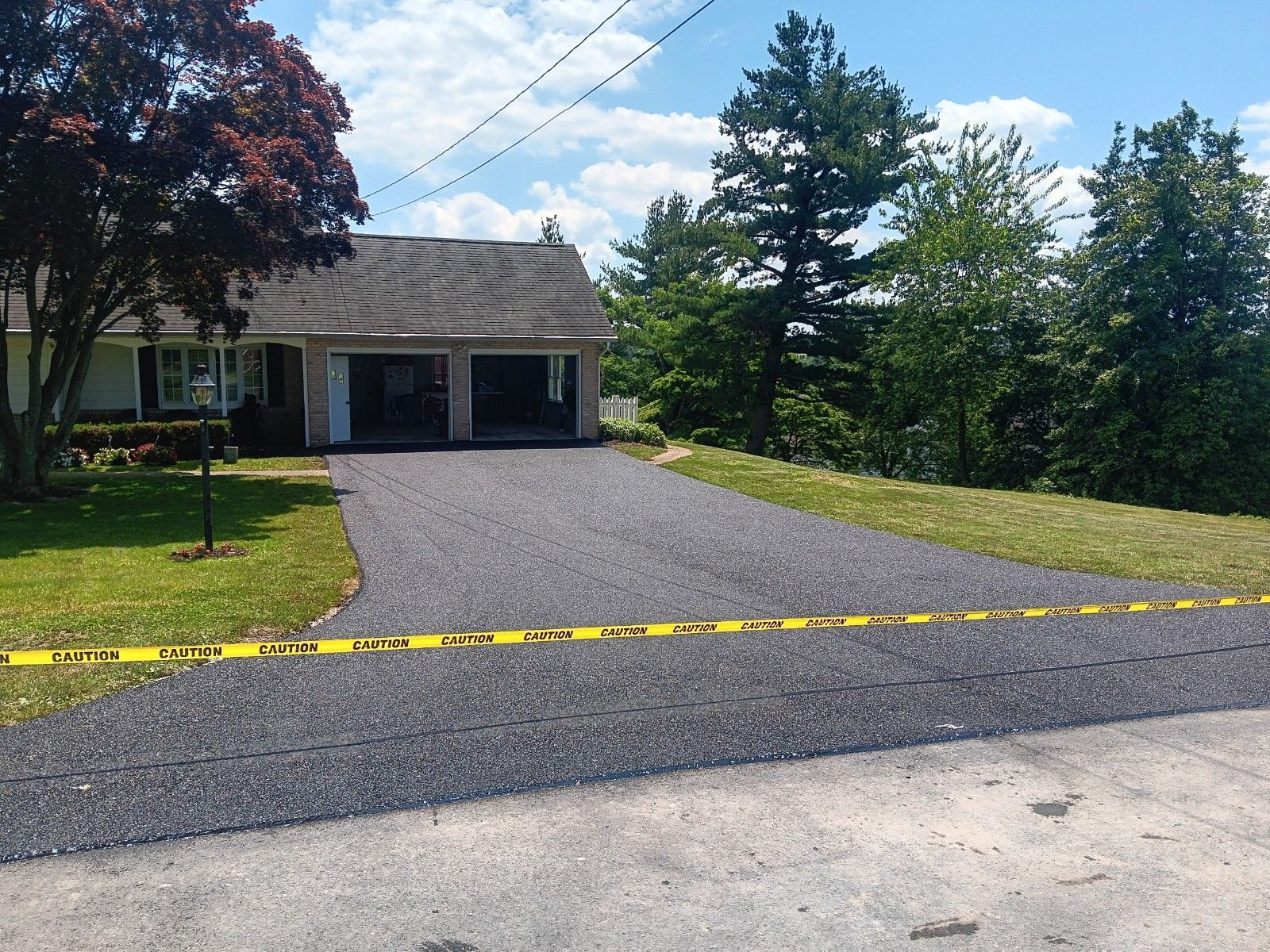 A driveway leading to a house with yellow tape on it