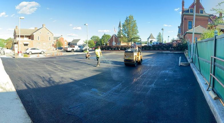 A panoramic view of a road being paved in a parking lot