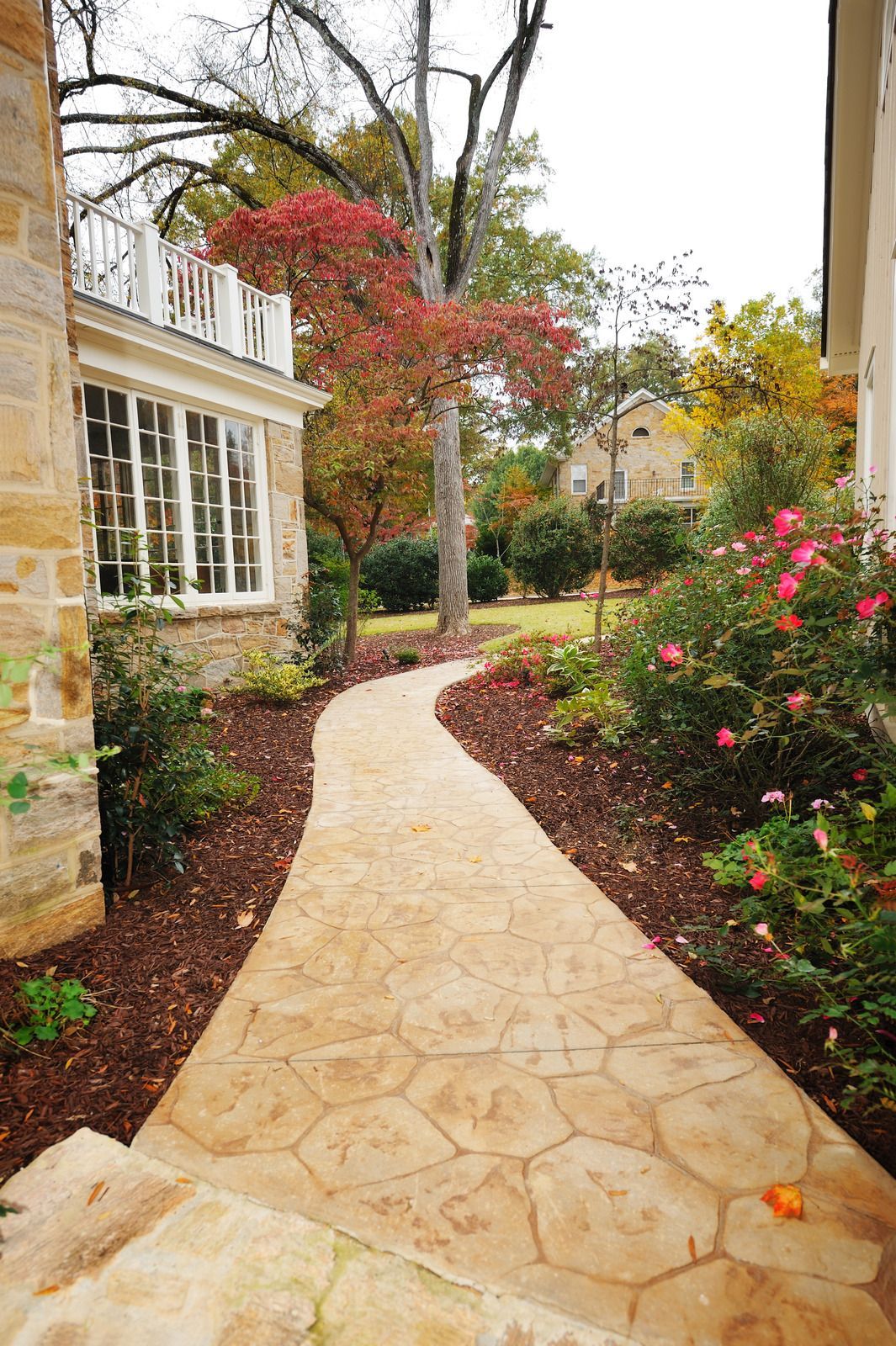A man is working on a patio in front of a house.