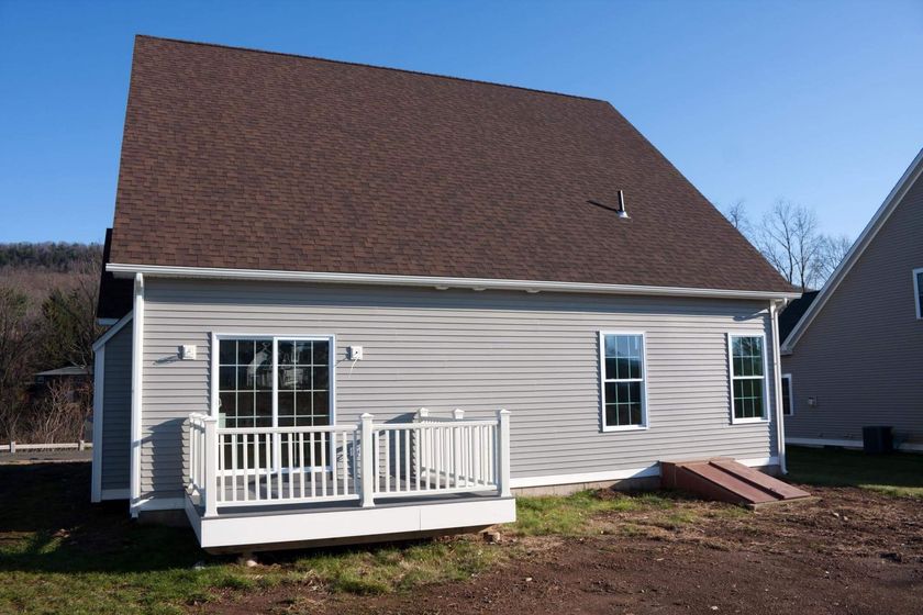 a house with a white porch and a brown roof