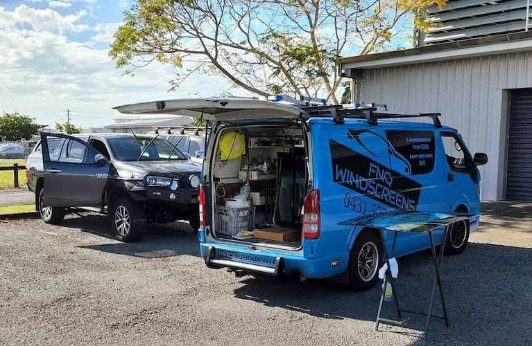A van and a ute are parked with their boot and door open — FNQ Windscreens in Bungalow, QLD