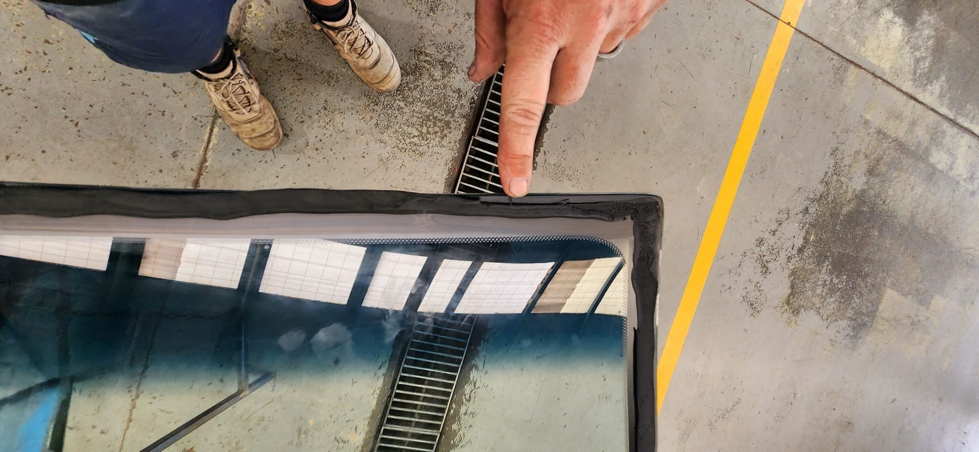 A Man is Installing a Rubber Seal on a Windshield on a Car — FNQ Windscreens in Bungalow, QLD