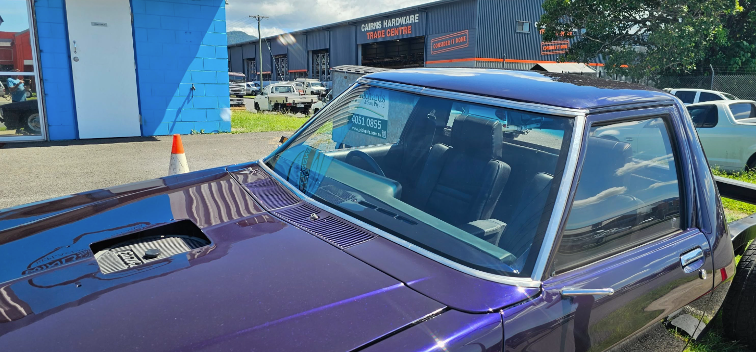 A Purple car outside with a garage in the background— FNQ Windscreens in Bungalow, QLD