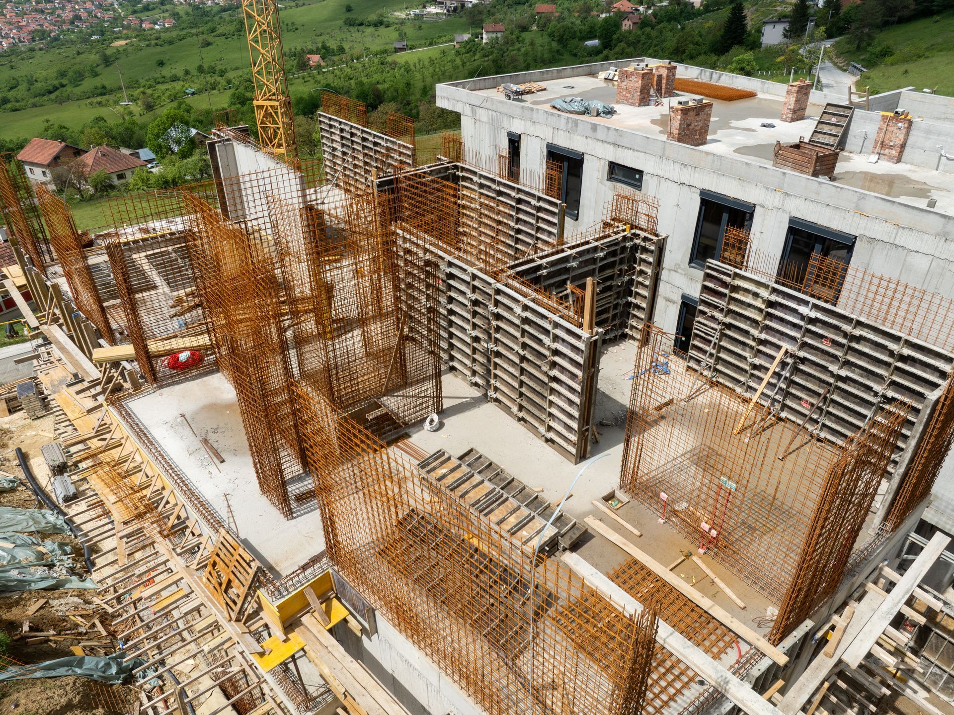 Construction site with exposed rebar and concrete formwork; a building in progress.