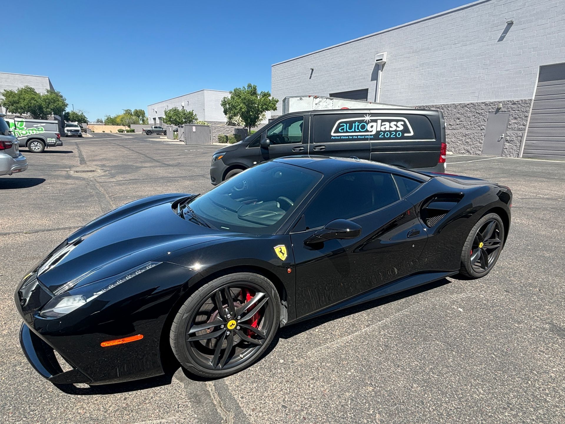A black ferrari 488 gtb is parked in a parking lot.
