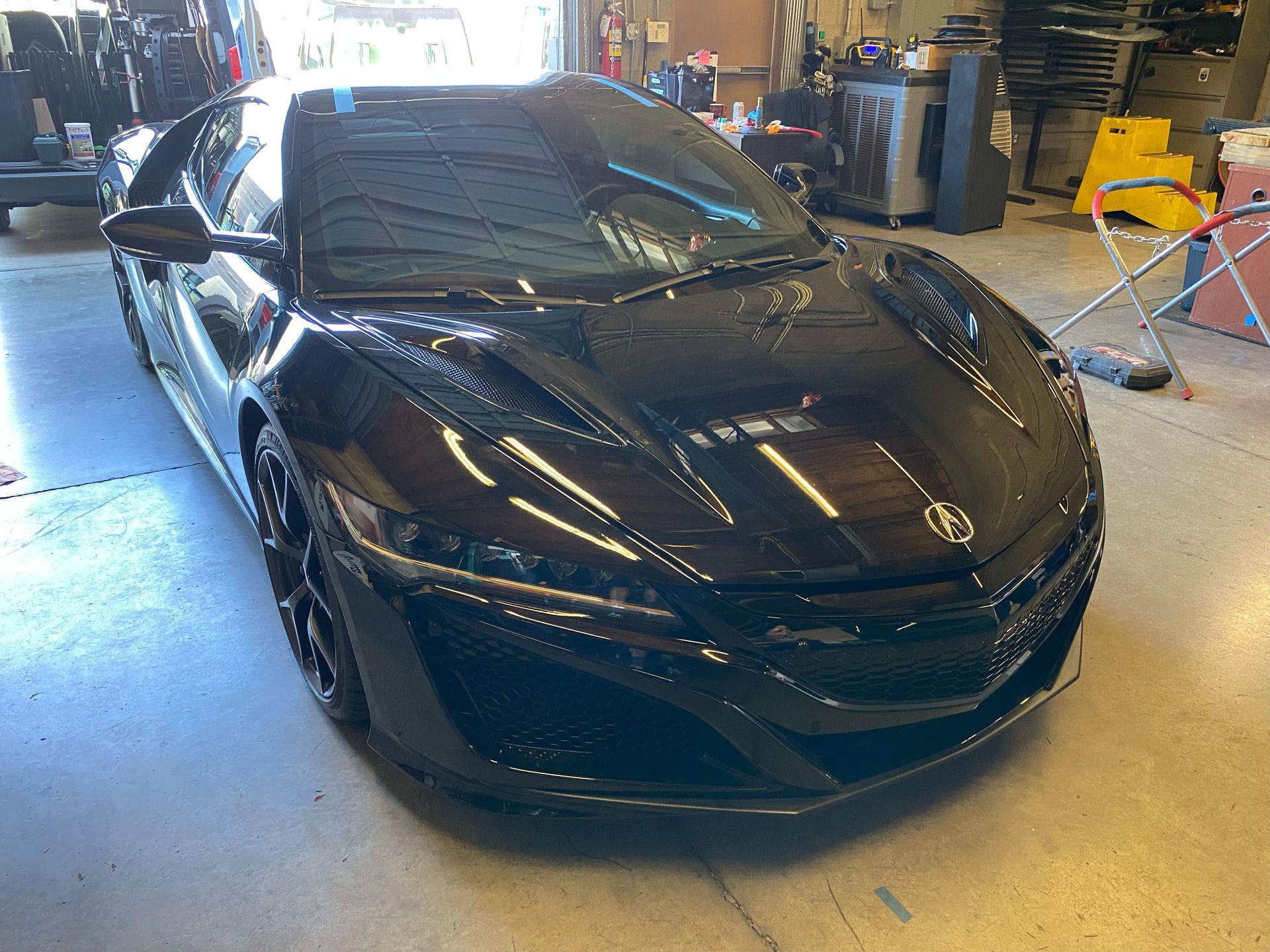 A black sports car is parked in a garage.