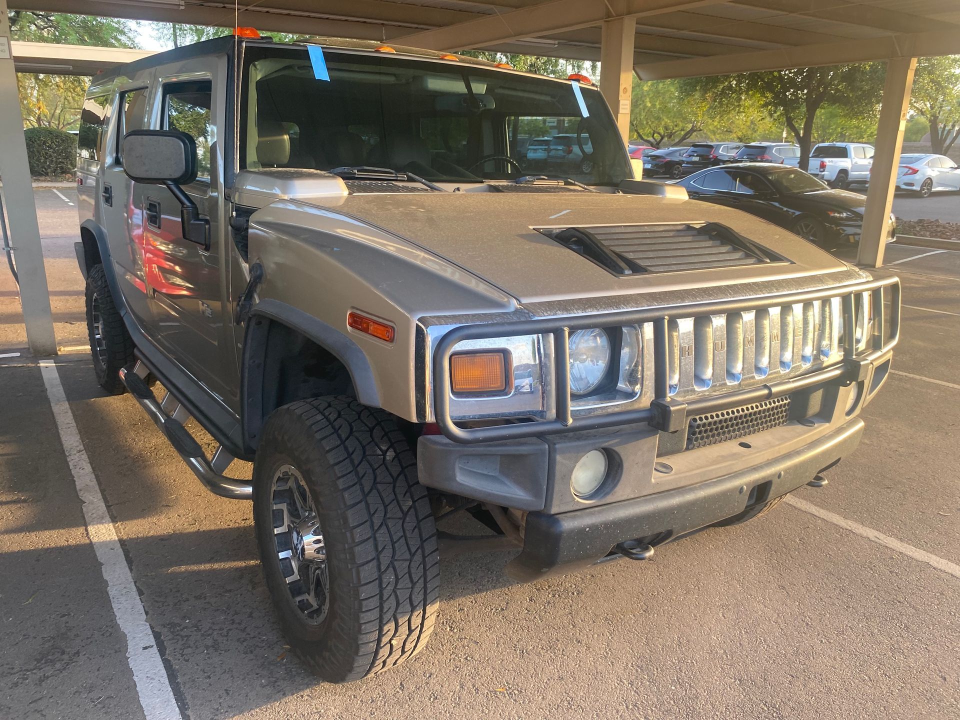 A hummer h2 is parked in a parking lot.