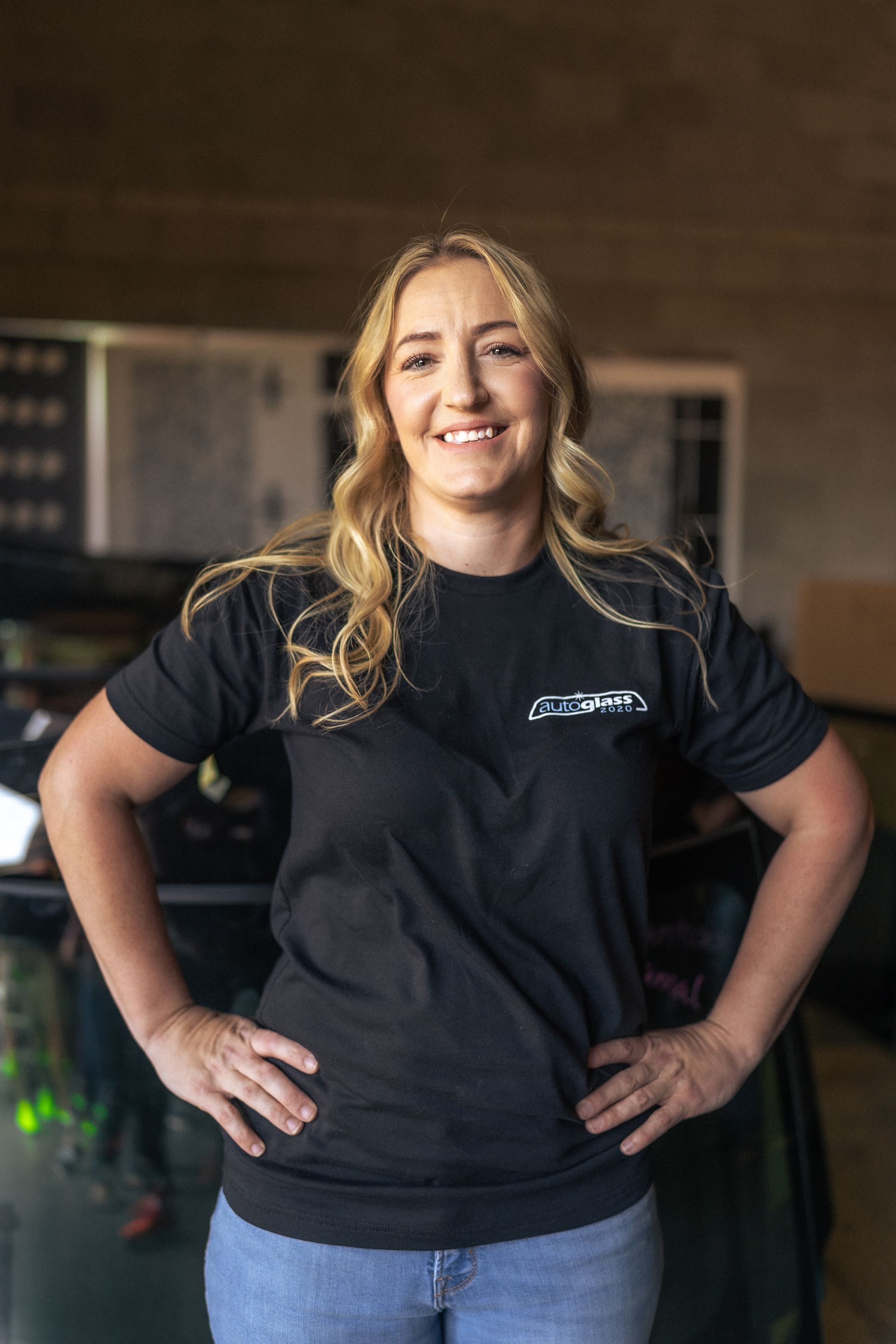 A woman in a black t-shirt is standing with her hands on her hips.