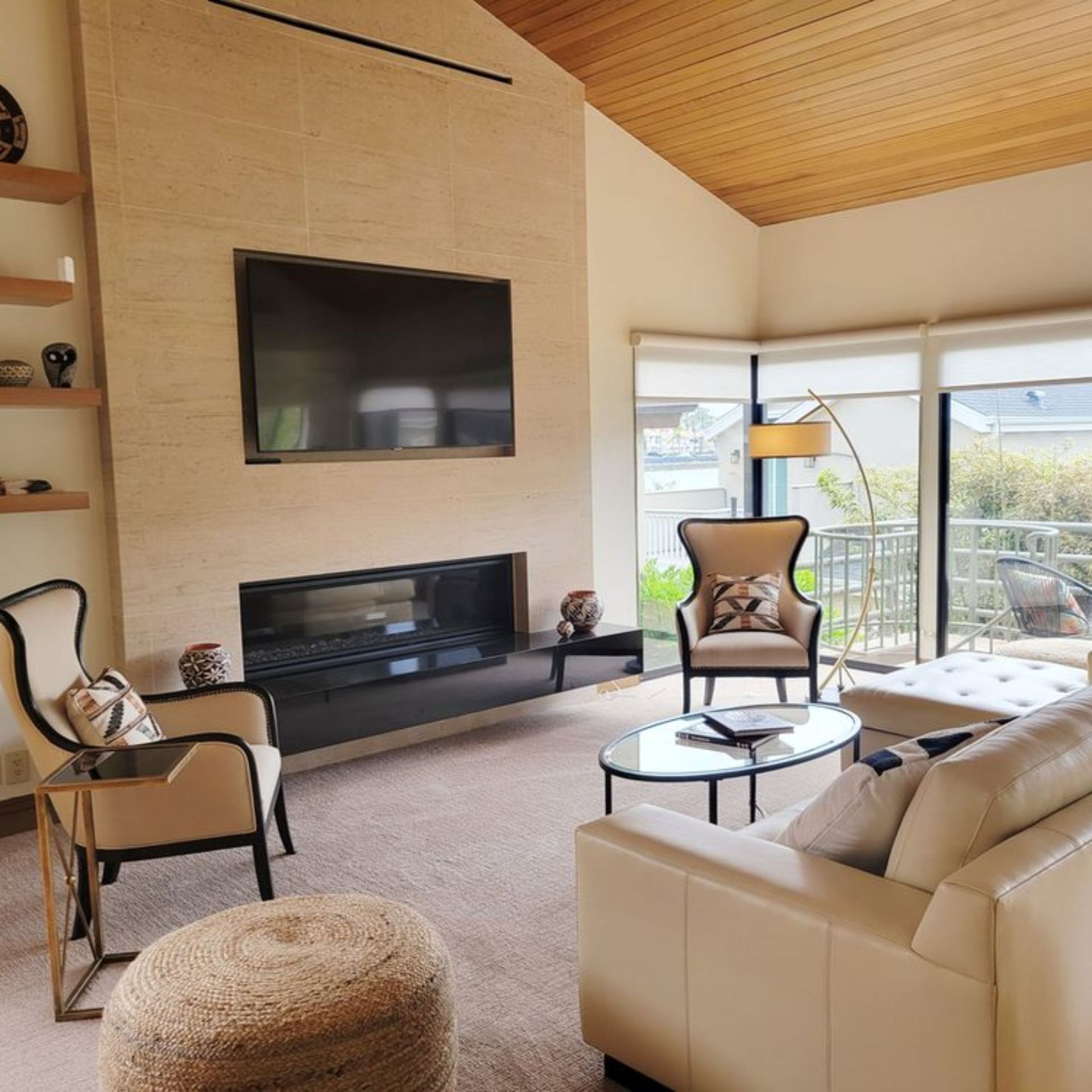 The right color - Living room with fireplace, TV, seating area, and large windows overlooking a balcony.