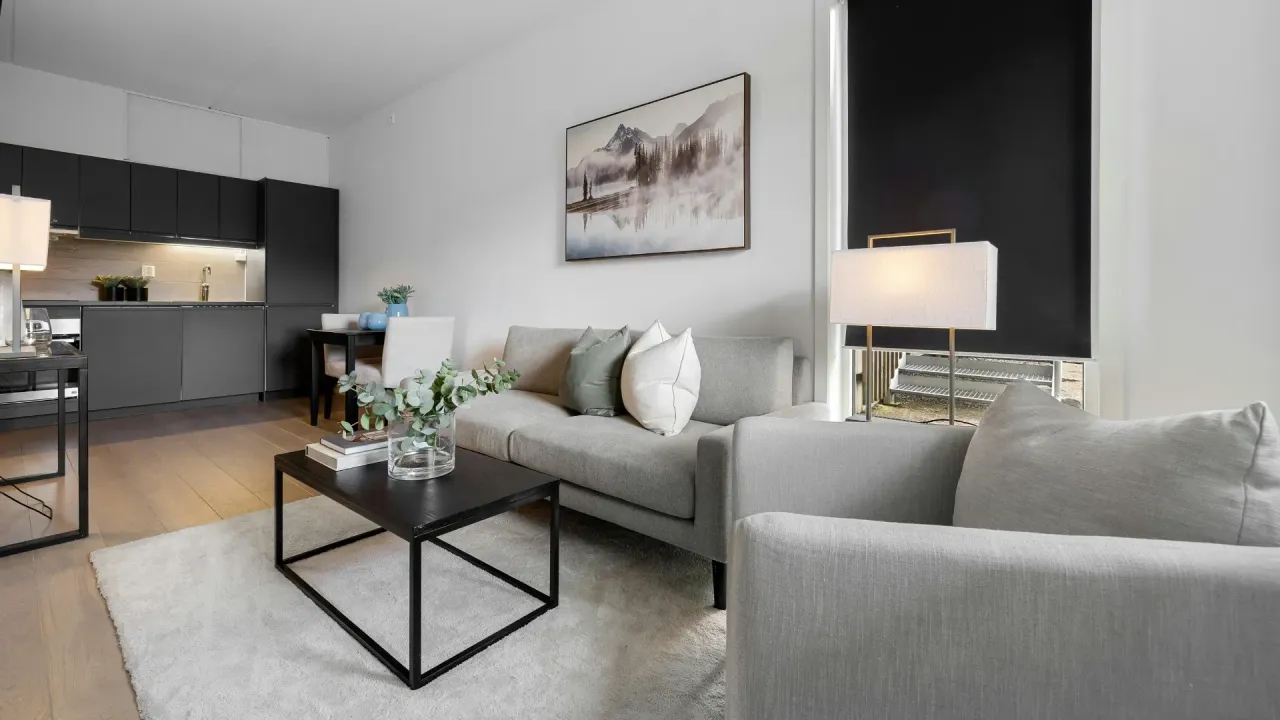 The right color - Modern living room with grey sofa, black coffee table, and kitchen in the background.