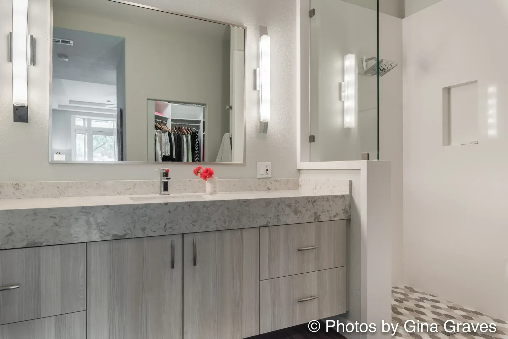 The right color - Modern bathroom with gray cabinets, marble countertop, large mirror, and glass shower.