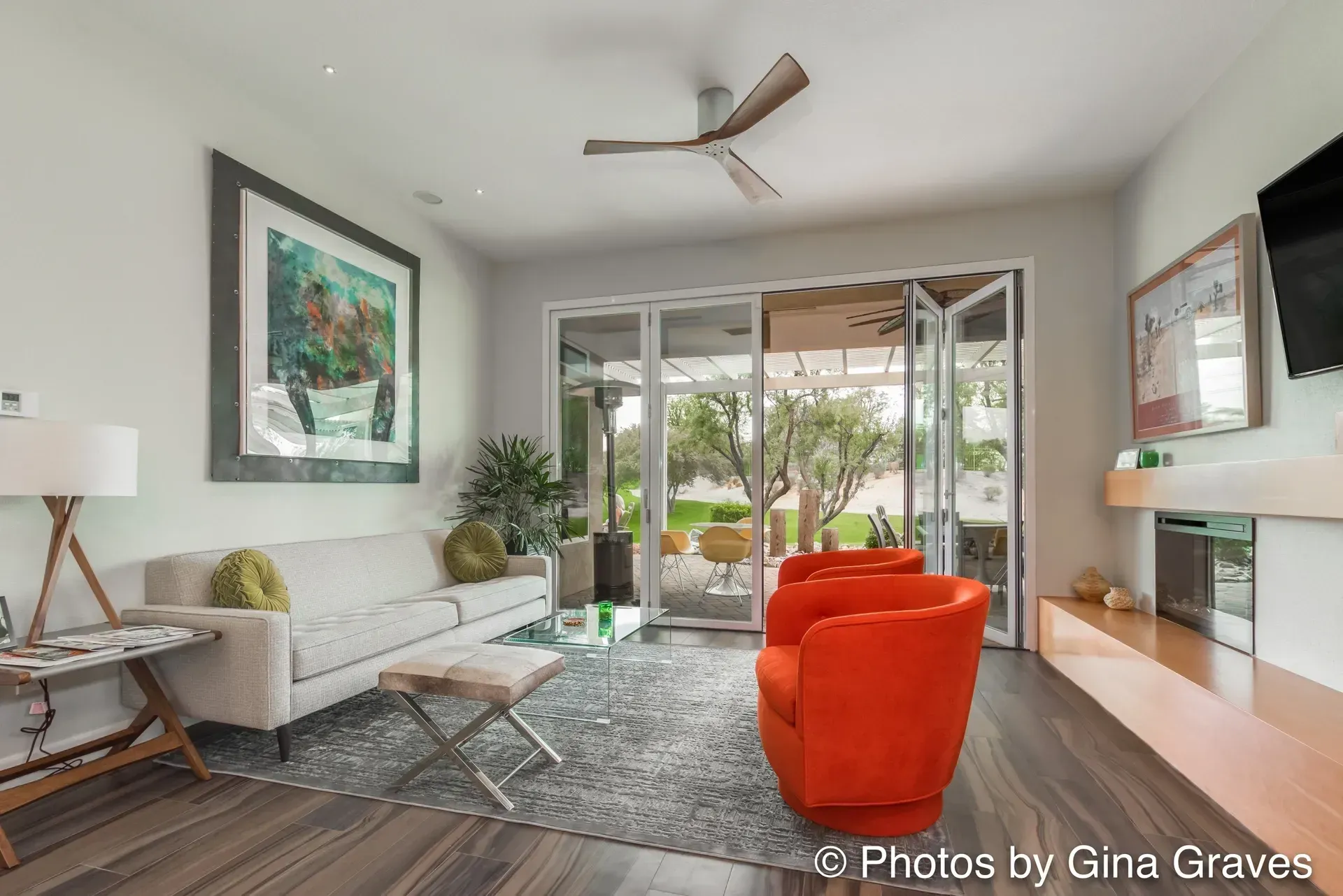 The right color - Modern living room with orange chairs, white sofa, and open doors to patio.