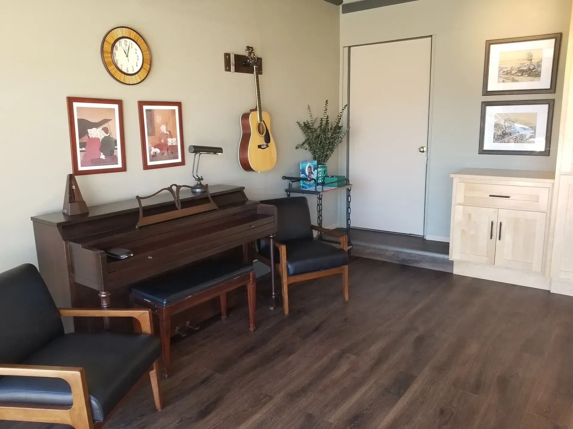 The right color - A room with a piano, guitars, artwork, and seating. Hardwood floors and a light gray wall.