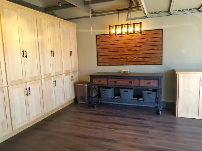 the right color - Garage with wood cabinets, table, and dark flooring.