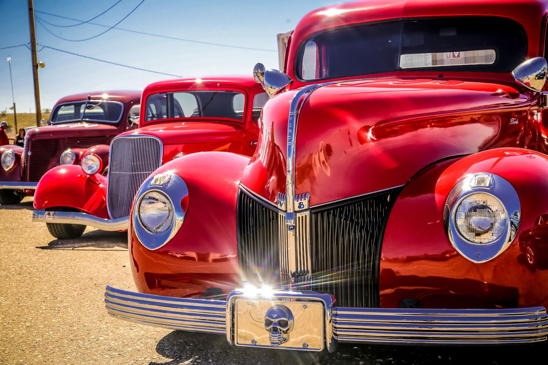 Person in gloves holding a silver radiator, with a green tool attached, in a factory setting.
