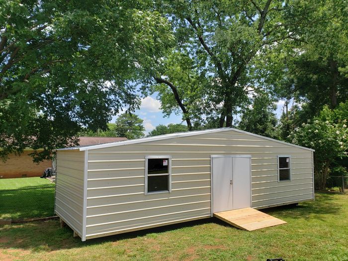 White shed under the tree — Huntsville, AL — Affordable Portable Buildings