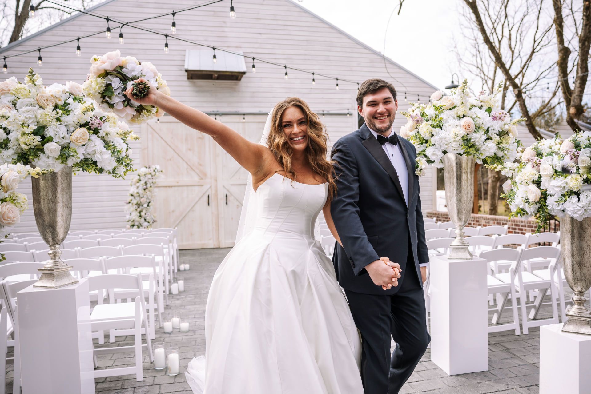 Bride and groom exiting wedding ceremony; bride raises bouquet at Fillauer Estate