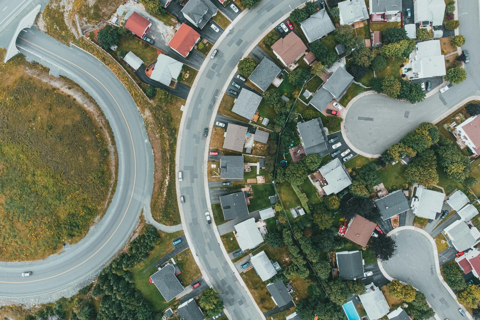 An aerial view of a residential area with houses and a highway.