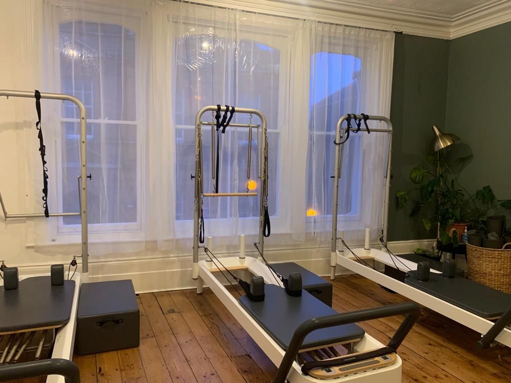 Three Pilates Tower machines in a row in the Pilates studio